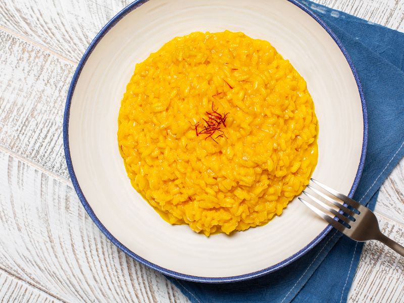 Rice with saffron plate over a white wood table and a blue napkin