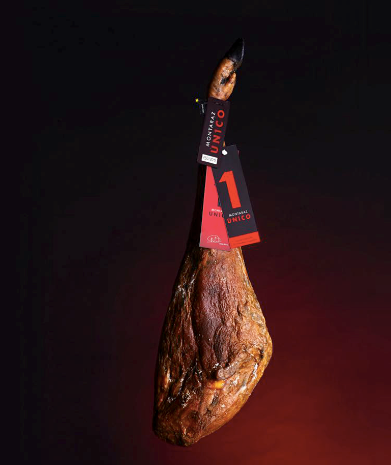 100% Iberico Acorn-fed Ham bone black and red background. Unico by Montaraz. Deliberico