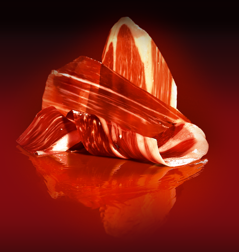 Iberico ham sliced with red background and reflexion by Montaraz. Deliberico