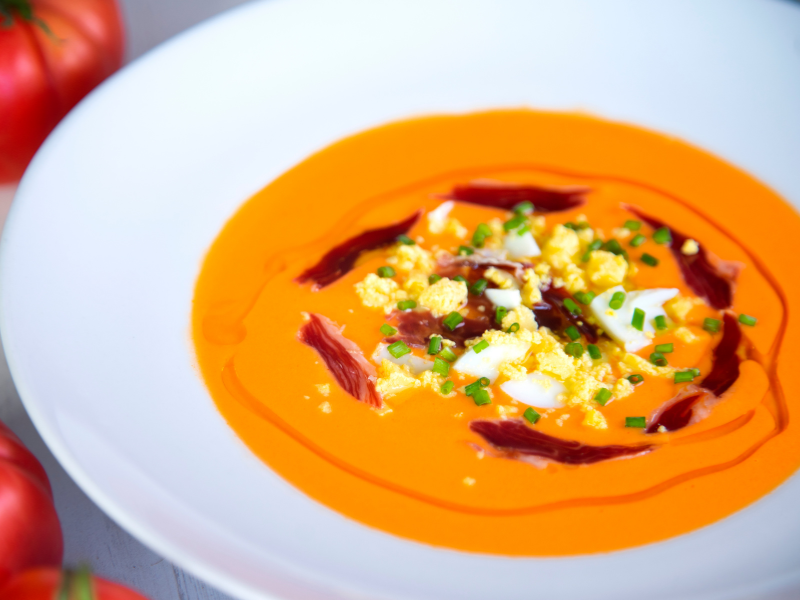 Salmorejo bowl garnished with ham, boiled eggs and chives
