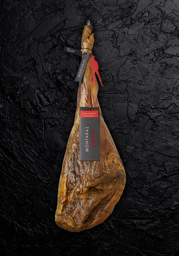 100% Iberico Acorn-fed Ham UNICO by Montaraz whole leg piece on black background