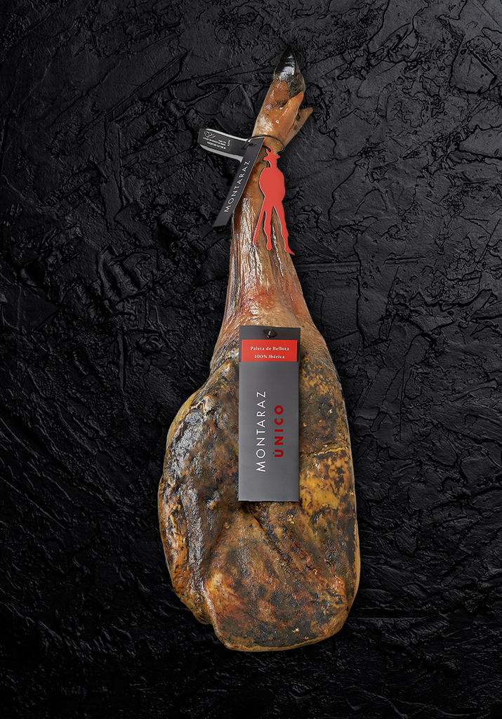 100% Iberico Acorn-fed Shoulder Ham UNICO bone black background by Montaraz. Deliberico