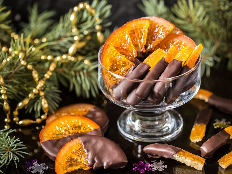 Candied oranges with chocolate in a glass bowl with christmas elements 