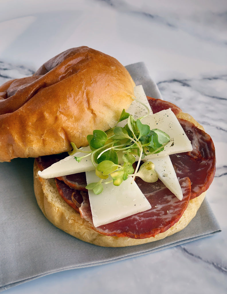 Cured loin by fermin burger with cheese and sprouts on top