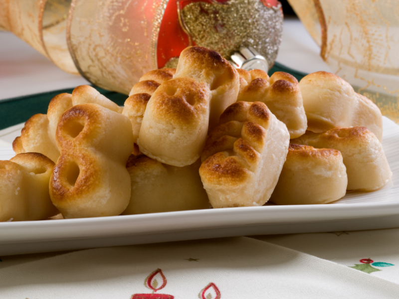 Marzipan figurines on a white dish with christmas decor gold and red on the back