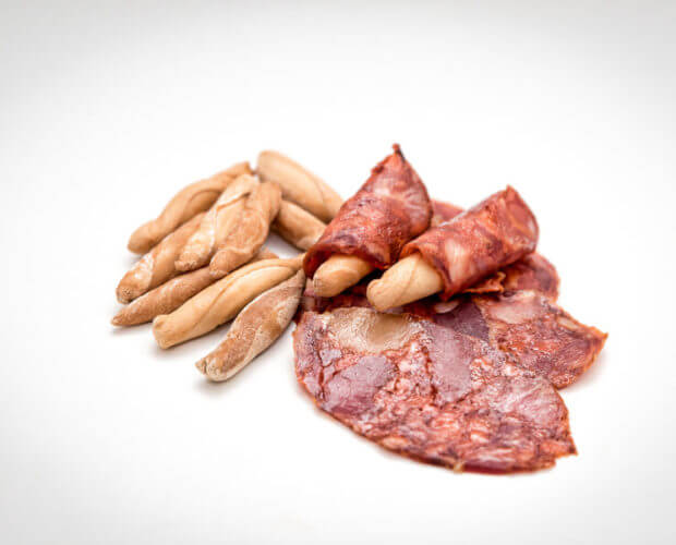 Obando Gourmet Rustic Breadsticks with cured meat on a white background