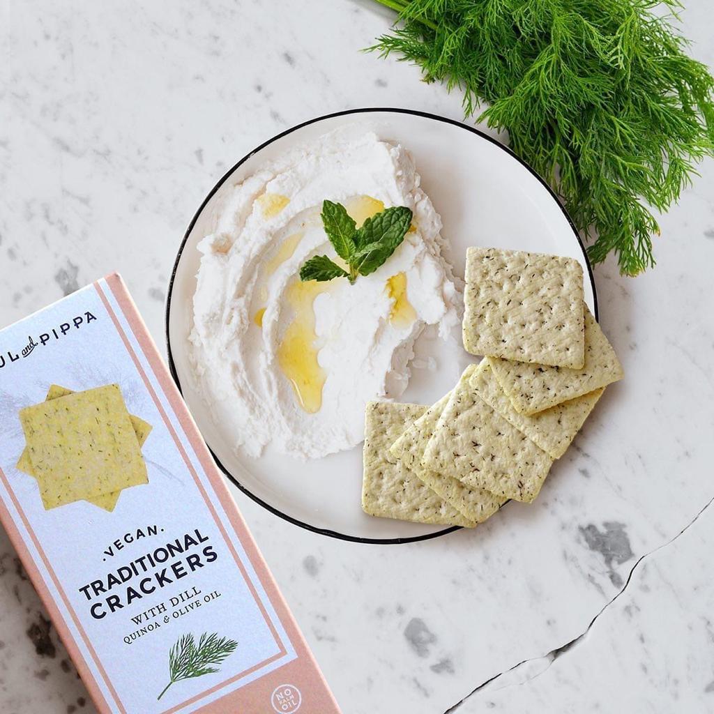 Vegan Dill Crackers by Paul & Pippa with a dipping plate on marble table