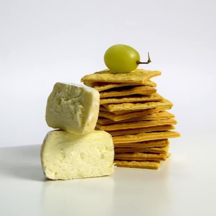 Parmesan Crackers by Paul & Pippa with parmesan cheese an a green grape on top