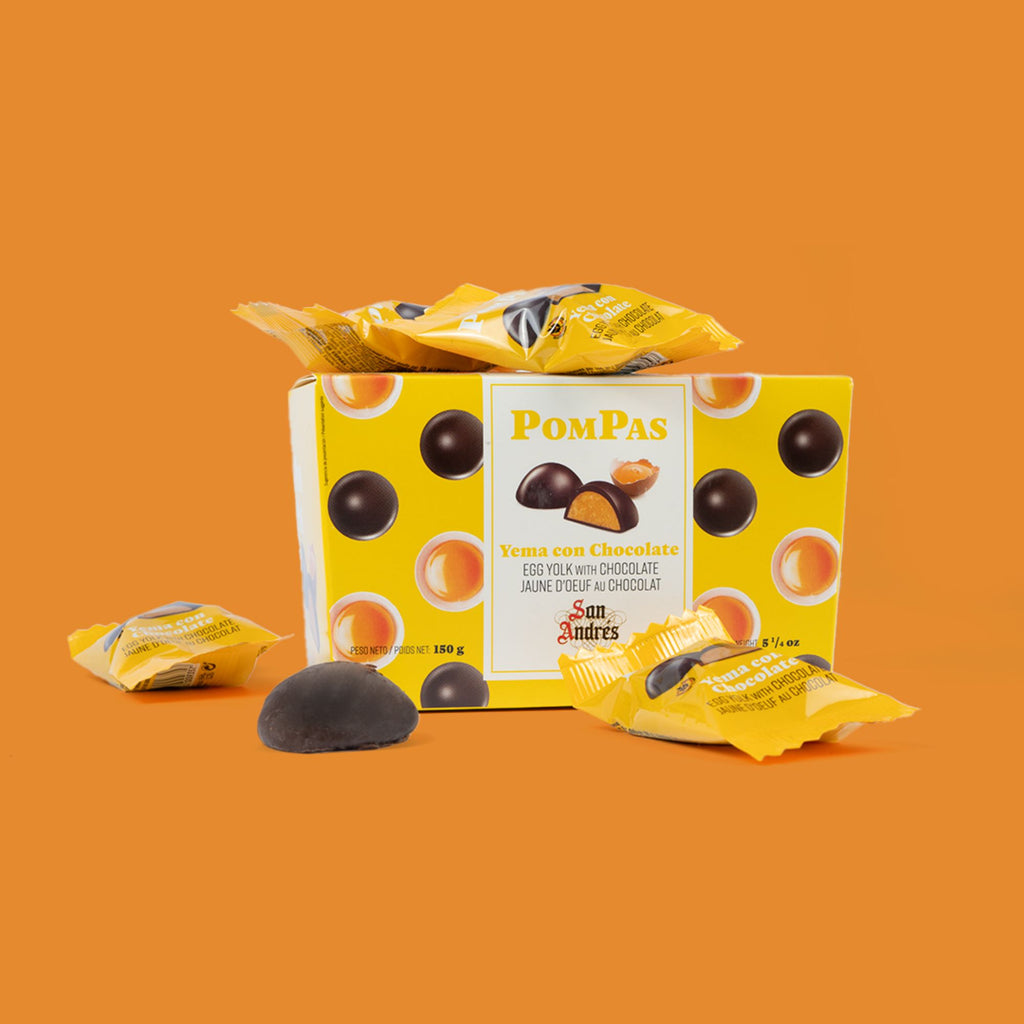 Box of PomPas chocolate candies with a few pieces on an orange background