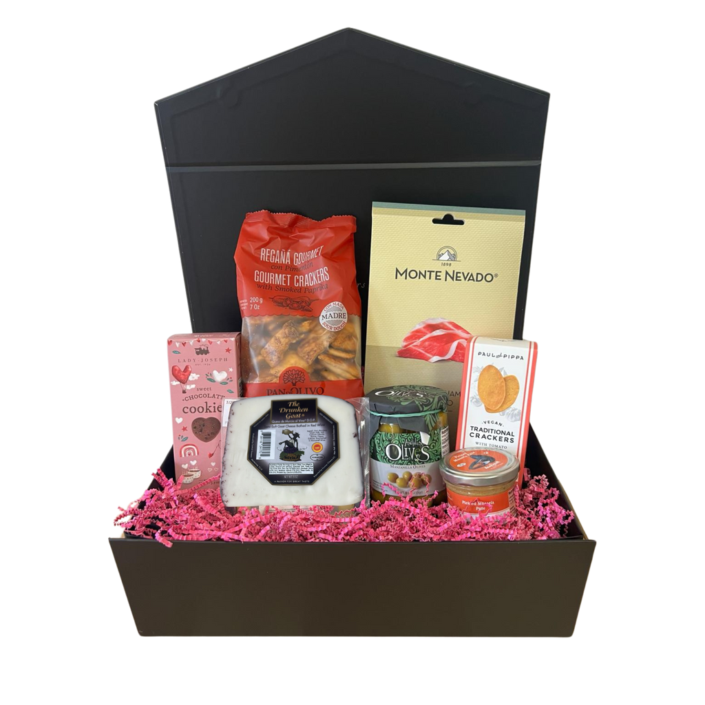 Unveil the contents of this gift box to elevate any celebration. Inside, you'll find a delightful assortment featuring artisan Serrano ham, delicious goat cheese, exquisite olives, crisp Reganas mini flatbread and tomato crackers, creamy mussels pate, indulgent heart chocolate cookies – a perfect array of flavors for your special celebration in our black gift box.