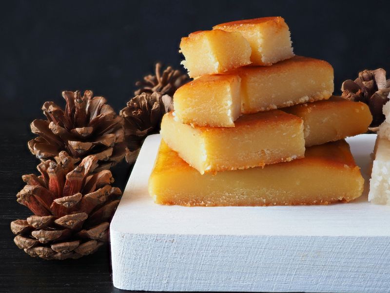Toasted Yolk Nougat over white board and pine cones