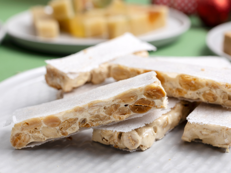 Alicante Nougat pieces on a white plate with blurred background