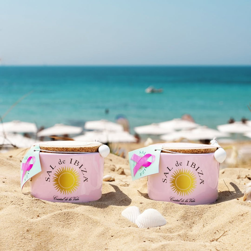  'Sal de Ibiza'Salt 2 Pink container with cork lid and pink ribbon label on a beach scene