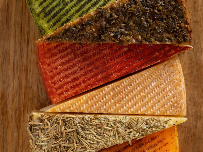 Assorted types of cheese wedges from Vega Sotuelamon on a wooden board