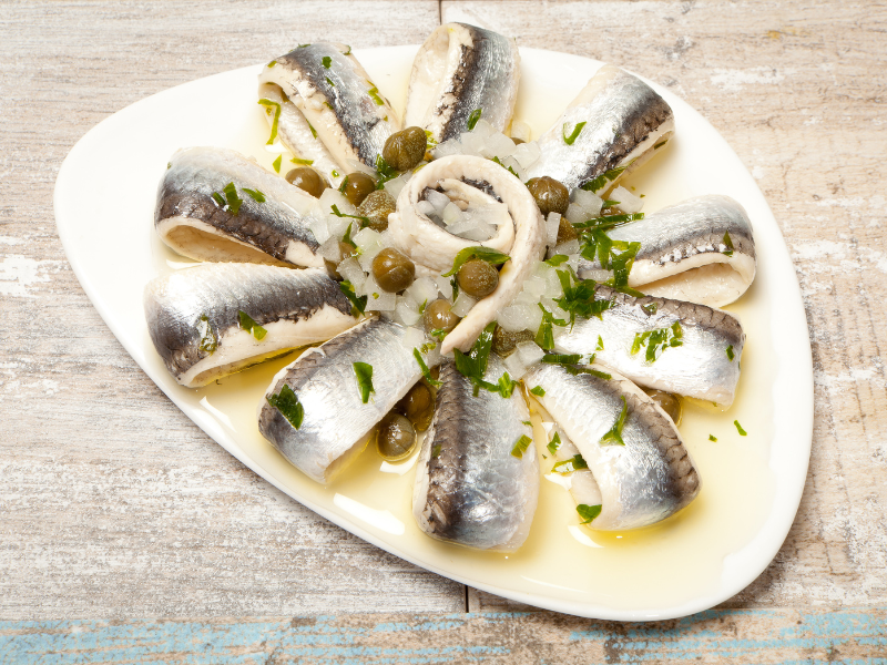 White Cantabrian Anchovies marinated with vinegar tapas plate with capers and olive oil