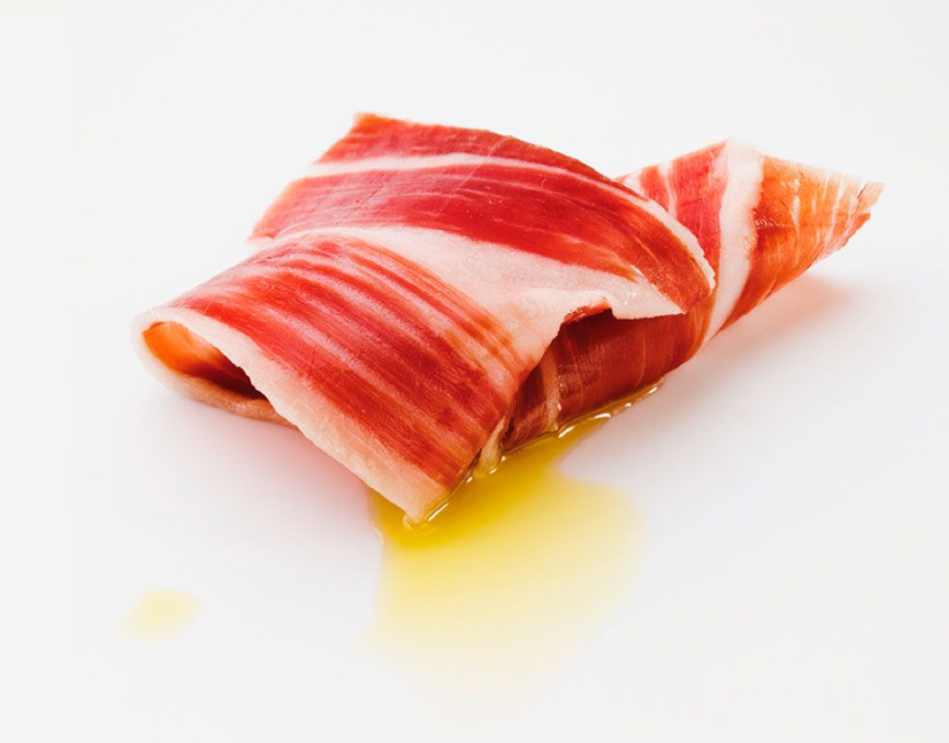 Slice of iberico ham on a white background by Montaraz. Deliberico