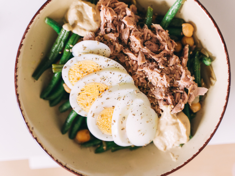 Tuna salad with boiled eggs, chickpeas and green beans in a bowl. DEliberico