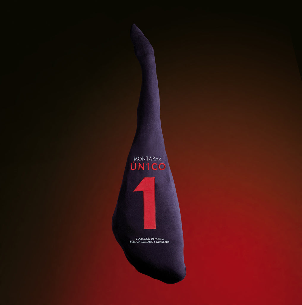 100% Iberico Acorn-fed Shoulder Ham bone in black fabric cover with black and red background. Unico by Montaraz. Deliberico