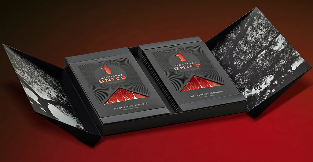 Family collection black gift box open with 6 packs of Unico iberico ham with red background by Montaraz. Deliberico