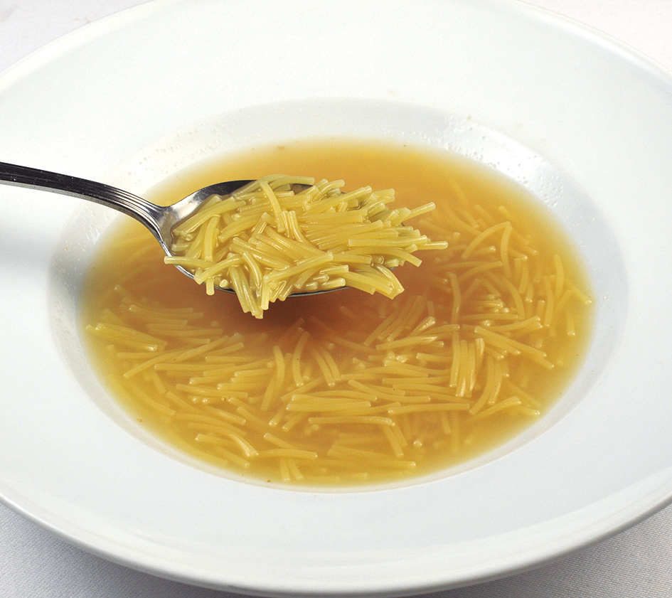Noodle "fideo" soup on a white bowl with spoon. Deliberico